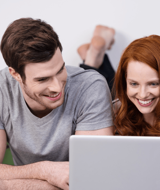 Happy couple with laptop | Karen's Advance Floors